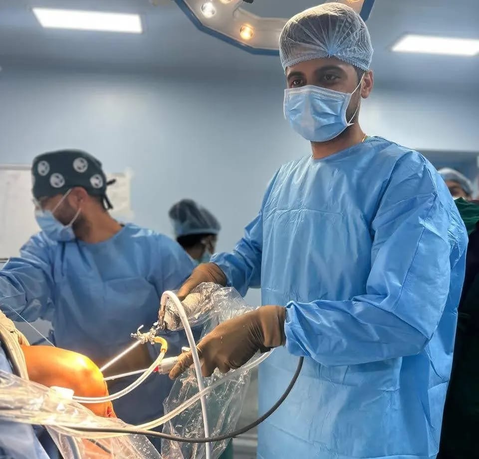 Arthroscopic instruments held during a minimally invasive knee procedure