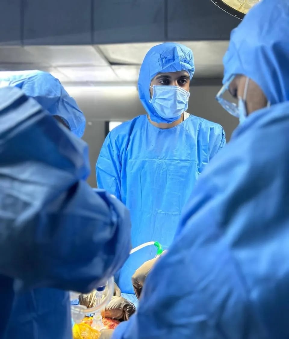 Dr. Dipen Ariwala concentrating during an operation, seen between two scrubbed colleagues